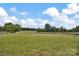 An expansive grassy field with a clear blue sky and scattered trees, indicative of a spacious lot at 8455 W Nc 152 Hwy, Mooresville, NC 28115
