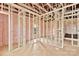 A well-lit living room under construction, showcasing pink insulation, wooden framework, and visible window openings at 8455 W Nc 152 Hwy, Mooresville, NC 28115