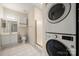 Well-lit bathroom with stacked washer/dryer, vanity, and a stand up shower at 8617 Coralbell Ln, Charlotte, NC 28213