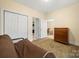 Bedroom featuring a double door closet, dresser, and a view into the laundry and living area at 8617 Coralbell Ln, Charlotte, NC 28213