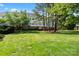 Well-maintained apartment building with a large, green lawn and mature trees at 8617 Coralbell Ln, Charlotte, NC 28213