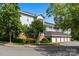 Multi-story apartment building with garage parking, trees, and well-manicured lawns at 8617 Coralbell Ln, Charlotte, NC 28213