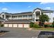 Multi-story apartment building with garage parking and well-maintained landscaping at 8617 Coralbell Ln, Charlotte, NC 28213