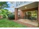 Cozy brick patio with sliding glass doors and outdoor seating, surrounded by lush greenery at 8617 Coralbell Ln, Charlotte, NC 28213