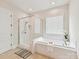 Bright bathroom featuring a soaking tub, glass-enclosed shower, and tile flooring at 873 Penny Royal Ave, Fort Mill, SC 29715