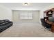 Spacious bonus room features a black leather couch, desk, chair, and neutral carpeting at 873 Penny Royal Ave, Fort Mill, SC 29715