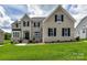 Charming two-story home with white brick, black shutters, and a well-manicured front lawn at 873 Penny Royal Ave, Fort Mill, SC 29715