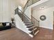 Elegant foyer featuring hardwood floors, staircase with iron railings, and decorative wall paneling at 873 Penny Royal Ave, Fort Mill, SC 29715