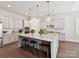 Open kitchen with granite countertops, light wood cabinets, and a large island with barstool seating at 873 Penny Royal Ave, Fort Mill, SC 29715