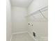 Small, white laundry room with a wire shelf and tiled flooring at 873 Penny Royal Ave, Fort Mill, SC 29715
