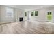 Bright living room features light wood floors, a fireplace, and large windows offering serene outdoor views at 9940 Manor Vista Trl, Kannapolis, NC 28027