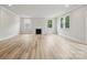 Bright living room features light wood floors, a fireplace, and large windows offering serene outdoor views at 9940 Manor Vista Trl, Kannapolis, NC 28027