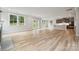 Open-concept living space with light wood floors, fireplace, and a kitchen with stainless steel appliances at 9940 Manor Vista Trl, Kannapolis, NC 28027