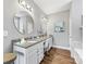 Bright bathroom featuring double vanities, granite countertops, and modern lighting fixtures at 1022 Doughton Ln, Indian Trail, NC 28079