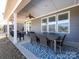 Covered patio with a ceiling fan, outdoor table and chairs, and a patterned rug at 1022 Doughton Ln, Indian Trail, NC 28079