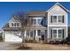 Charming two-story home with gray siding, stone accents, manicured landscaping, and inviting front porch at 1022 Doughton Ln, Indian Trail, NC 28079