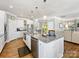 Well-lit kitchen featuring a large island with granite countertops and stainless steel appliances open to the living room at 1022 Doughton Ln, Indian Trail, NC 28079
