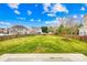 Large backyard with green grass, wooden fence, and view of the home's exterior at 10223 Kelso Ct, Charlotte, NC 28278