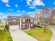 Two-story brick home features an attached garage, manicured lawn, and mature landscaping at 10223 Kelso Ct, Charlotte, NC 28278
