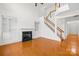 Bright living room boasts a fireplace, built-in shelving, hardwood floors and a staircase at 10223 Kelso Ct, Charlotte, NC 28278