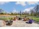 An inviting backyard patio with Adirondack chairs, a fire pit and umbrella are perfect for entertaining outdoors at 10321 Solar Way, Charlotte, NC 28278