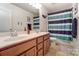 Charming bathroom with a double sink vanity and a shower with blue striped curtain at 10321 Solar Way, Charlotte, NC 28278