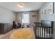 Bedroom includes a crib, chair, dresser, and a bright alphabet rug on carpeted flooring at 10321 Solar Way, Charlotte, NC 28278