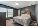 Calm bedroom with a modern rustic headboard, patterned bedding, and neutral-colored walls at 10321 Solar Way, Charlotte, NC 28278