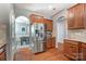 Kitchen view featuring stainless steel refrigerator, wood cabinets, and arched doorway to dining area at 10321 Solar Way, Charlotte, NC 28278