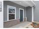 Close-up of a stylish townhome entrance with a gray door, brick details, and window at 104 Ciara Pl # B, Mooresville, NC 28117