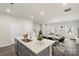 Bright kitchen boasts an island with seating, stainless steel sink, quartz countertops, and a view of the dining area at 104 Ciara Pl # B, Mooresville, NC 28117