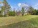 Spacious backyard features mature trees and a large grassy area, ideal for outdoor activities at 1102 Balcorn Pl, Charlotte, NC 28214