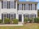 Inviting home entrance with black door, manicured shrubs, and stone-lined flowerbeds for curb appeal at 1102 Balcorn Pl, Charlotte, NC 28214