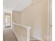 Hallway with neutral paint, gray carpeting, and half wall with white trim at 1102 Balcorn Pl, Charlotte, NC 28214