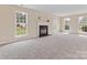Bright living room features a fireplace, plush carpet, and large windows showcasing the outdoor view at 1102 Balcorn Pl, Charlotte, NC 28214