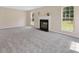 Spacious carpeted living room features fireplace, neutral walls, and large windows providing natural light at 1102 Balcorn Pl, Charlotte, NC 28214