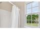 Corner of a shower-tub combination featuring a white shower curtain and a window at 1102 Balcorn Pl, Charlotte, NC 28214