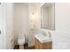 Powder room featuring a modern vanity with framed mirror, toilet, and stylish fixtures at 1119 N Myers St, Charlotte, NC 28206