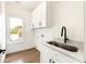 Bright laundry room featuring modern cabinetry, sink with sleek black faucet, and window at 1119 N Myers St N Myers St, Charlotte, NC 28206