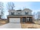 Well-manicured two-story home with a combination brick and siding exterior, an attached two-car garage, and ample curb appeal at 117 Obadiah Ct, Troutman, NC 28115