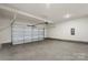 Spacious garage with concrete floor, overhead lighting, and a modern garage door system at 117 Obadiah Ct, Troutman, NC 28115