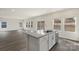 Kitchen island featuring granite countertops, wood floors, and stainless steel appliances at 117 Obadiah Ct, Troutman, NC 28115