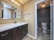 Bathroom with vanity, toilet, and tiled shower in adjacent room at 11911 Maria Ester Ct, Charlotte, NC 28277