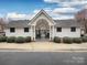 Inviting community clubhouse entrance, featuring a covered porch and manicured bushes at 11911 Maria Ester Ct, Charlotte, NC 28277