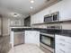 Updated kitchen features white cabinets, stainless steel appliances, and granite countertops at 11911 Maria Ester Ct, Charlotte, NC 28277