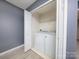 Hallway laundry closet with white washer and dryer set and wire shelving for storage at 11911 Maria Ester Ct, Charlotte, NC 28277