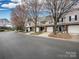 A row of townhomes with mature trees lining the street and well-maintained landscaping at 11911 Maria Ester Ct, Charlotte, NC 28277