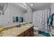 Bathroom featuring modern vanity, grey and white shower curtain and bright lighting at 12545 Druids Glen Dr, Pineville, NC 28134