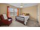Bedroom with abundant natural light, orange accents, a ceiling fan, and a cozy chair at 12545 Druids Glen Dr, Pineville, NC 28134