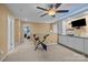 A spacious bonus room featuring an exercise bike, built-in shelves, and neutral carpeting at 12545 Druids Glen Dr, Pineville, NC 28134